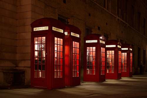 phone booth five red lined phone booths near building phone
